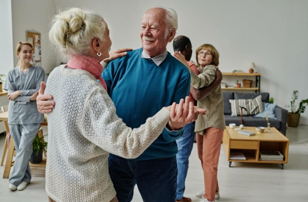 Older adult couples smiling as they dance in a senior living community.